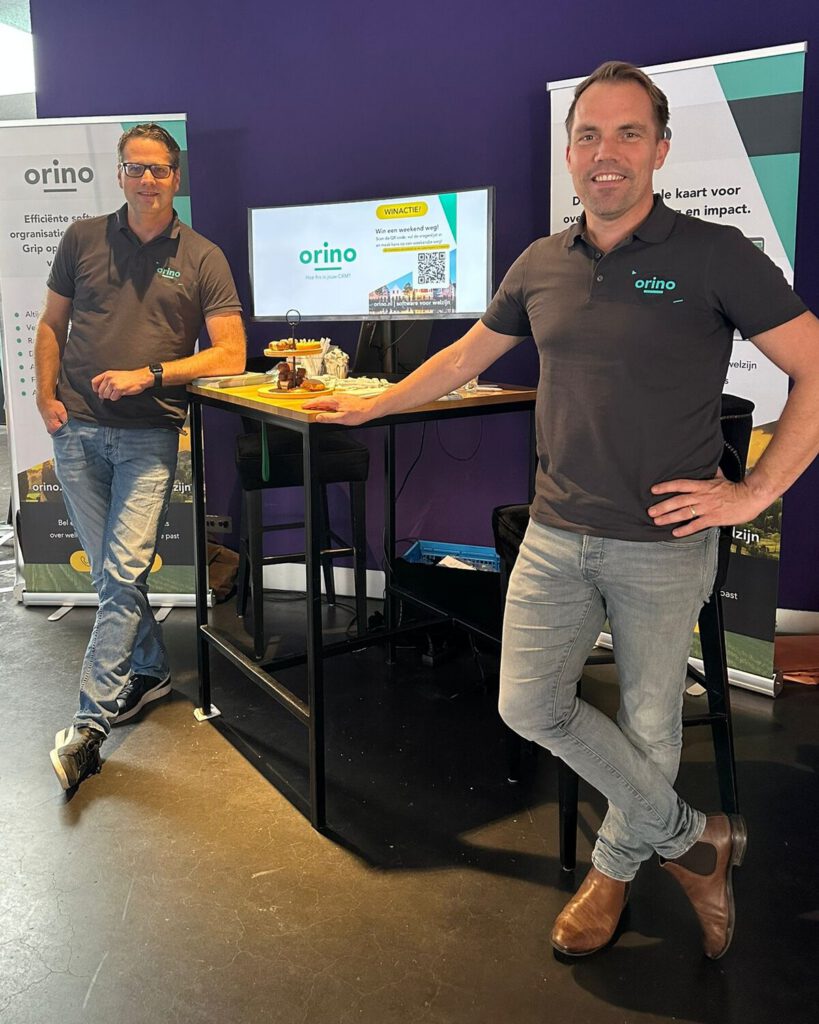 Jos Honig (links) en Ron Deurloo (rechts) in een Orino-polo bij de stand van Orino.